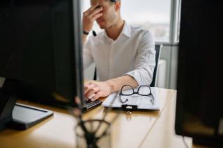 Personne au travail devant un écran d'ordinateur dans un bureau éclairé