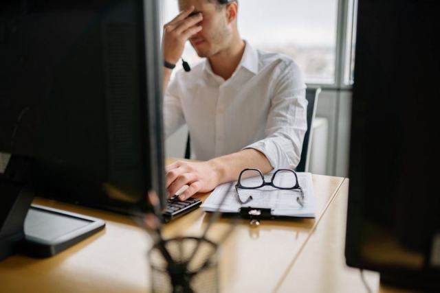Personne au travail devant un écran d'ordinateur dans un bureau éclairé