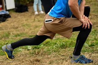 Sportive assise au sol qui étire ses ischio-jambiers en fin de séance